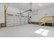 Spacious garage with overhead door, stairs, and water heater at 295 Rudd Rd, Youngsville, NC 27596