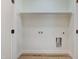Empty laundry room with washer and dryer hookups, shelving, and plank flooring at 295 Rudd Rd, Youngsville, NC 27596
