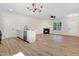 Open concept living space with wood floors, kitchen island, fireplace, and natural light at 295 Rudd Rd, Youngsville, NC 27596