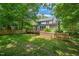 A spacious fenced backyard featuring a large deck and plenty of mature trees at 3 Cobble Glen Ct, Durham, NC 27713