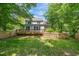 A spacious fenced backyard featuring a large deck, mature trees, and a well maintained lawn at 3 Cobble Glen Ct, Durham, NC 27713
