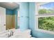 Bathroom with blue walls, white fixtures, and a window that provides natural light at 3 Cobble Glen Ct, Durham, NC 27713