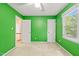 Bedroom with vibrant green walls and white trim with two doors leading to other rooms at 3 Cobble Glen Ct, Durham, NC 27713