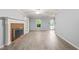 Bright living room with a red brick fireplace, built in shelving, and new wood-look flooring at 3 Cobble Glen Ct, Durham, NC 27713