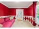 Stylish sitting room featuring bright red walls with harlequin accents and neutral carpeting at 3 Cobble Glen Ct, Durham, NC 27713