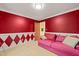 Sitting room featuring bright red paint, white harlequin accents, and comfy pink sofa at 3 Cobble Glen Ct, Durham, NC 27713