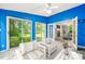 Bright sunroom with blue walls, tile floors, and open access to the living room at 3 Cobble Glen Ct, Durham, NC 27713