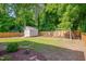 Private fenced-in backyard with mature trees, a shed, and a swing set at 3003 University Dr, Durham, NC 27707