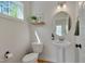 Charming powder room with pedestal sink, round mirror, and natural light at 3003 University Dr, Durham, NC 27707
