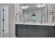 Elegant bathroom featuring a double vanity with gray cabinets and a large mirror at 3003 University Dr, Durham, NC 27707
