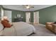Lovely green bedroom with carpet, ceiling fan, a comfy chair, and ample natural light at 3003 University Dr, Durham, NC 27707
