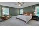 Green-walled bedroom features a ceiling fan, seating area, and a cozy atmosphere with natural light at 3003 University Dr, Durham, NC 27707