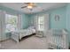 Charming light blue bedroom featuring a bed, crib, and ample natural light at 3003 University Dr, Durham, NC 27707