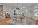 Sunlit dining room with wood floors, table, and access to staircase and living room at 3003 University Dr, Durham, NC 27707