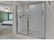 Modern walk-in shower with white subway tiles and a glass door, adjacent to a bedroom at 3003 University Dr, Durham, NC 27707