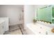 Bright primary bathroom with tiled floor, large window above the soaking tub, and glass enclosed shower at 3034 Winfred Dell Ln, Cary, NC 27511