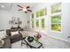 Bright living room boasts large windows, a ceiling fan, and cozy seating perfect for relaxation at 3034 Winfred Dell Ln, Cary, NC 27511