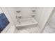 A clean and simple bathroom with a tub and a toilet, featuring white marble floors at 309 Beacon Dr, Pittsboro, NC 27312