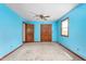Bright blue bedroom featuring a ceiling fan, ample storage, natural light, and a vibrant atmosphere at 319 Knox Rd, Gibsonville, NC 27249