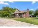 Charming brick home featuring a covered porch, mature trees, and a well-maintained lawn at 319 Knox Rd, Gibsonville, NC 27249