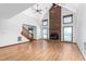 Sunlit room with a floor-to-ceiling brick fireplace, hardwood floors, and expansive windows at 319 Knox Rd, Gibsonville, NC 27249