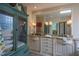 Bright bathroom with double vanity, tub, glass block window, and tiled shower at 3325 Falls River Ave, Raleigh, NC 27614