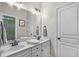 Traditional-style bathroom with dual sinks, white cabinets, and modern fixtures at 3325 Falls River Ave, Raleigh, NC 27614