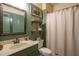Charming bathroom featuring open shelving and neutral shower curtain at 3325 Falls River Ave, Raleigh, NC 27614