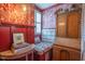 Stylish bedroom featuring a seating nook, patterned wallpaper, and hardwood floors at 3325 Falls River Ave, Raleigh, NC 27614