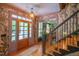 Elegant entryway with hardwood floors, staircase, designer wallpaper, and view to the green living room at 3325 Falls River Ave, Raleigh, NC 27614