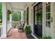 Charming front porch with brick floor, white railings, rocking chairs, plants and black front door at 3325 Falls River Ave, Raleigh, NC 27614