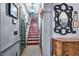 Hallway with decorative staircase, art, mirror, and hardwood floors at 3325 Falls River Ave, Raleigh, NC 27614