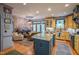 Open kitchen and living area featuring an island, custom cabinets, and modern appliances at 3325 Falls River Ave, Raleigh, NC 27614