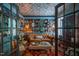 Elegant living room with blue walls, shelves of books, tufted brown sofa, and doors at 3325 Falls River Ave, Raleigh, NC 27614