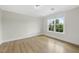Bedroom with hardwood floors and a large window providing natural light and treetop views at 340 Allister Dr # 301, Raleigh, NC 27609