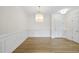 Bright dining room with hardwood floors, decorative wainscoting, and a decorative light fixture at 340 Allister Dr # 301, Raleigh, NC 27609