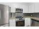 Modern kitchen with stainless steel appliances, granite counters, and gray backsplash at 340 Allister Dr # 301, Raleigh, NC 27609
