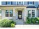 Charming front porch with stone accents and lush greenery, leading to a black front door at 3536 Greenville Loop Rd, Wake Forest, NC 27587