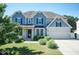 Charming two-story home with a manicured lawn, blue siding, black shutters, and a two-car garage at 3536 Greenville Loop Rd, Wake Forest, NC 27587