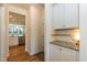 Hallway features granite counter, white cabinets and stainless steel appliances in the background at 3536 Greenville Loop Rd, Wake Forest, NC 27587