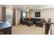 Bright, carpeted living room featuring a large sectional, ceiling fan, and natural light from two windows at 3536 Greenville Loop Rd, Wake Forest, NC 27587