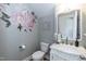 Elegant powder room with ornate mirror, floral wall art, and classic fixtures at 3536 Greenville Loop Rd, Wake Forest, NC 27587