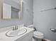 Bright bathroom features a white sink with framed mirror, toilet and shower with glass door at 4119 Toroella St, Durham, NC 27704