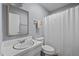 Bright bathroom features a white vanity with framed mirror, toilet and tub with a shower curtain at 4119 Toroella St, Durham, NC 27704