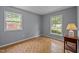 Bright bedroom features parquet floors, a ceiling fan, and large windows with outdoor views at 4119 Toroella St, Durham, NC 27704