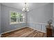 Dining room with hardwood floors, natural light from a large window, and classic trim at 4119 Toroella St, Durham, NC 27704