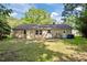 View of home's exterior featuring back entrance, lawn, and trees on a sunny day at 4119 Toroella St, Durham, NC 27704