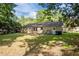 View of home's exterior featuring back entrance, lawn, and trees on a sunny day at 4119 Toroella St, Durham, NC 27704