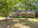 Cozy brick home with a well-maintained lawn, accented by mature trees and a classic design at 4119 Toroella St, Durham, NC 27704