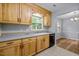 Well-lit kitchen with wooden cabinets, stainless steel dishwasher, and stylish tile flooring at 4119 Toroella St, Durham, NC 27704
